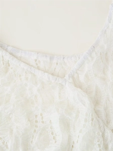 Close-up of white floral lace texture and stitching details on the summer dress neckline