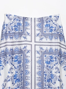 Detail shot of white maxi skirt with blue paisley patterns and invisible zipper side