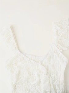 Detailed close-up of white layered lace fabric with floral patterns and ruffled edges