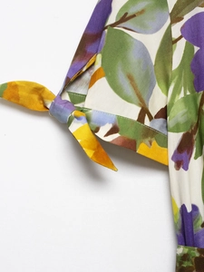 Macro detail of summer dress cuff featuring floral print and tie-up bow design