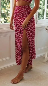 Dettaglio di crop top floreale rosso e gonna lunga con spacco alto e laccio laterale