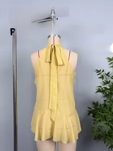 Detail of yellow halter neck chiffon top with tie-knot bow and ruffled layered hemline