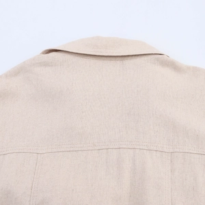Detailed macro view of beige linen fabric texture and collar stitching on shirt dress