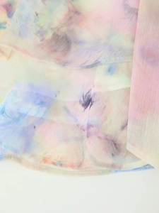 Close-up of tie-dye lace hem with pastel watercolor print and delicate stitching detail
