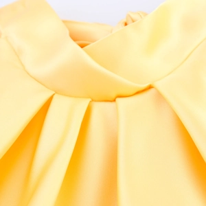 Detail of elegant pleated high collar on smooth yellow satin sleeveless dress fabric