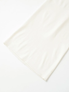 Detailed close-up showing the fine knit texture and hemline of a white halter dress