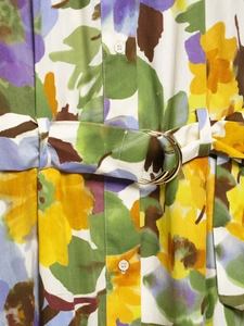 Detail of floral print summer dress with golden double ring buckle belt and white buttons