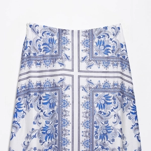 Elegant white maxi skirt with blue floral patterns and invisible side zipper closure