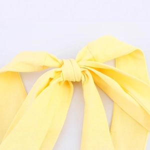 Elegant pale yellow halter neck maxi dress featuring a soft knot detail at the front