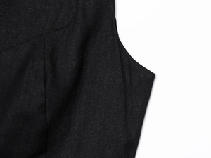 Detailed close-up of smooth stitching and linen blend fabric texture on a black dress