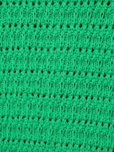 Macro texture del tessuto a maglia verde brillante con motivi traforati verticali
