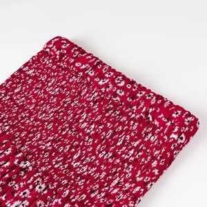 Dettaglio ravvicinato della vita elasticizzata su un abito estivo rosso a fiori