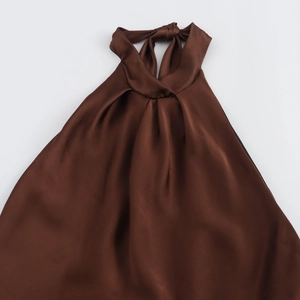 Detail of dark brown satin halter top featuring a twist knot neckline and draped texture