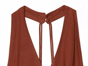 Detail of rust red halter dress showing metallic hook closure and textured fabric