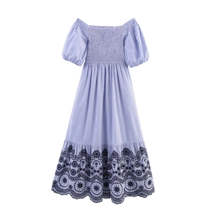 Detail of blue striped dress featuring floral embroidery and wavy scalloped hemline