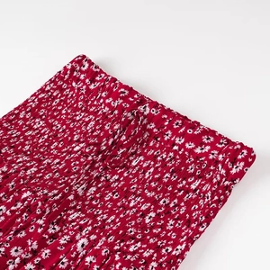 Dettaglio dell'abito estivo a fiori rossi con vita elastica arricciata e coulisse regolabile