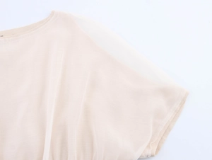 Detail of light beige chiffon top featuring a ribbed neckline and translucent fabric texture