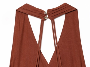 Detail of rust red halter neck dress with pleated collar and crystal button closure