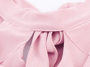 Close-up of pink halter neck top showing delicate fabric texture and layered drapery
