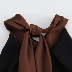 Detailed macro view of the elegant brown satin halter neckline with decorative tie design