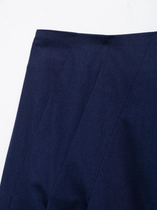Detailed close-up of navy blue pleated linen skirt fabric texture and clean folding lines