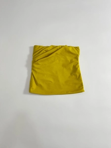 Dettaglio di un top a fascia giallo brillante con elegante design a pieghe sul davanti