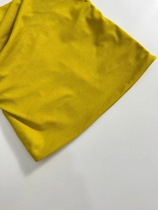 Dettaglio della trama del tessuto a maglia giallo brillante con drappeggio morbido e fine