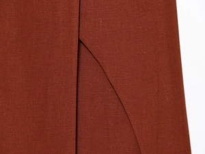 Macro shot of stitching detail and high-density woven fabric on a caramel summer dress