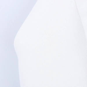 Macro shot of white knitted fabric texture showing soft detailed pleated dress ruffles
