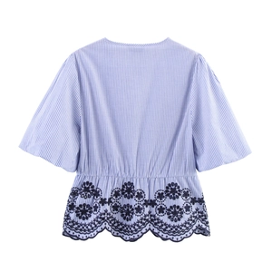 Detailed view of blue striped short sleeve top with floral hollow embroidery at the hem