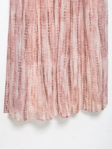Λεπτομέρεια από το ροζ πλισέ στρίφωμα με tie-dye σχέδιο και κομψή υφή του υφάσματος