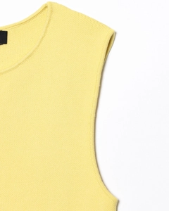 Gros plan sur la maille fine et l'encolure du haut sans manches jaune pâle élégant