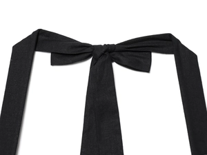 Detailed view of a black fabric bow tie on a mini dress featuring textured cotton fabric