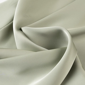 Macro shot showing silky satin fabric texture and premium drape of the sage green dress