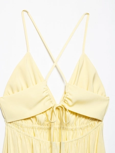 Detail of yellow backless sundress featuring crossover straps and drawstring neckline