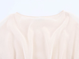 Detailed close-up of light beige knit top featuring a clean round neckline and soft texture