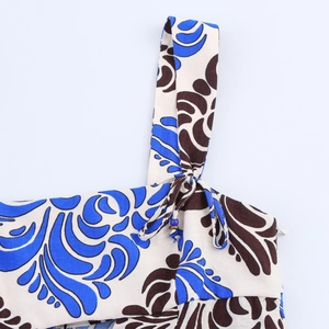 Detailed shot of printed dress with blue bead straps and hidden zipper closure