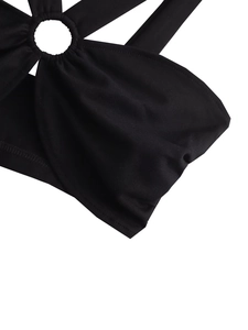 Close-up of black halter top with circular ring connector and detailed fabric texture