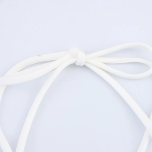 Macro detail of white pleated dress tie cord showing fiber texture and knotted finish