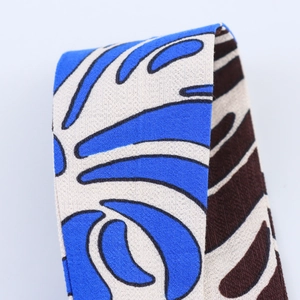 Close-up of high-density woven straps with tropical leaf and contrast wave patterns