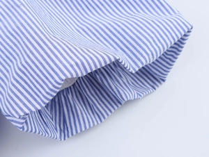 Detailed close-up of blue and white striped shirt cuff with elastic pleated design