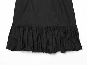 Detailed close-up of the black bubble hem with ruffled texture on the mini dress