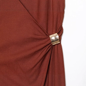 Rust red summer dress with elegant gold metal ring detailing and pleated fabric texture
