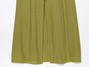 Detail view of grass green linen midi dress showing the single button and middle slit texture