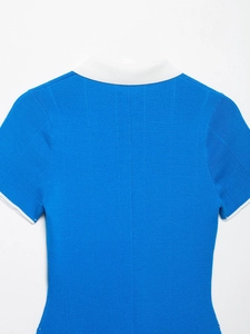 Dettaglio del tessuto a maglia a coste blu brillante con colletto a polo bianco