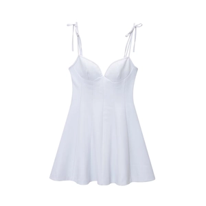 Detailed flat lay of white A-line mini dress with bow-tie straps and V-neckline detail
