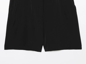Détail de la combinaison noire à taille haute avec fermeture éclair et poches latérales