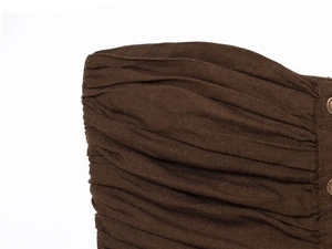 Macro detail of dark brown ruched fabric and decorative metallic buttons on tube top