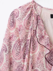 Close-up of elegant paisley print fabric with soft cream and fuchsia chiffon ruffles