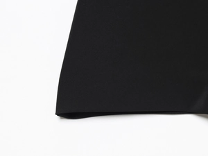 Macro de la texture du tissu en sergé noir et de la couture nette de l'ourlet du combishort